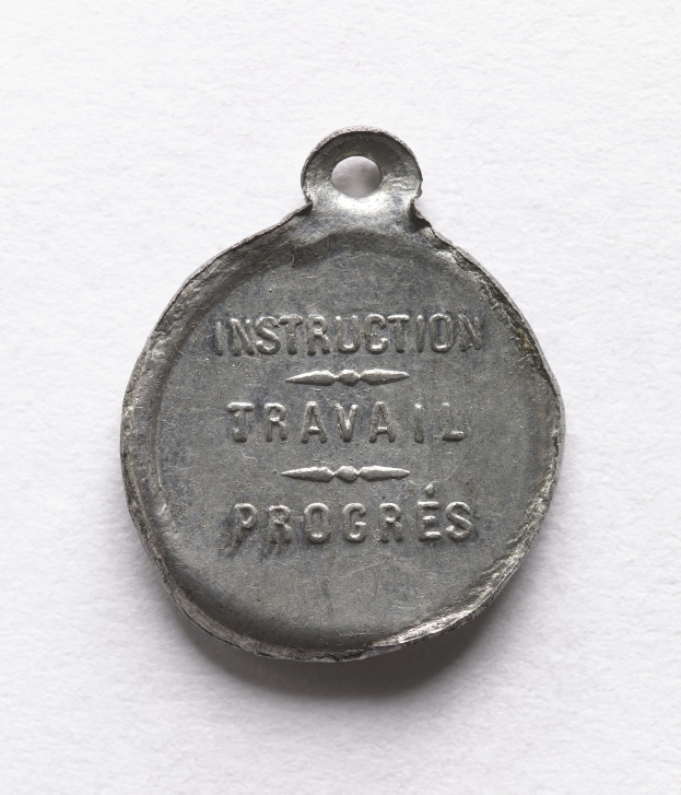 Eine Silbermedaille mit der Inschrift "Instruction Travail Progress" auf einem weißen Hintergrund.