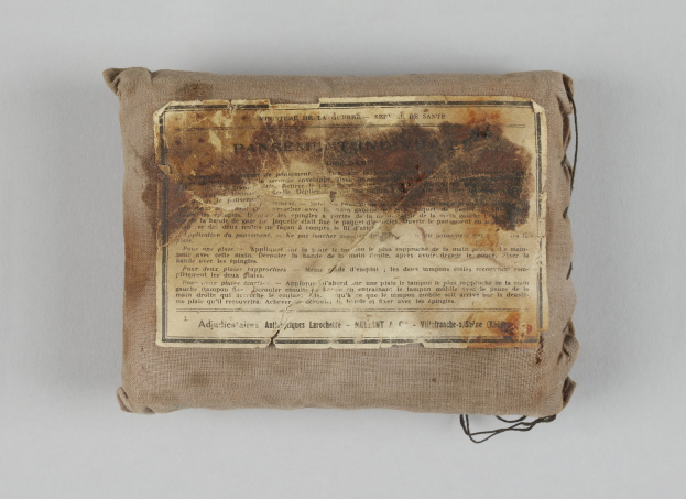 Kleiner Verbandskasten mit einem informativen Blatt Papier obenauf.