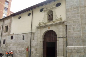 Ein Mann fährt auf einem Motorrad eine Straße entlang neben der Kirche Santa Maria del Fiore, mit einer Person auf einem Fahrrad links und dem Himmel im Hintergrund.