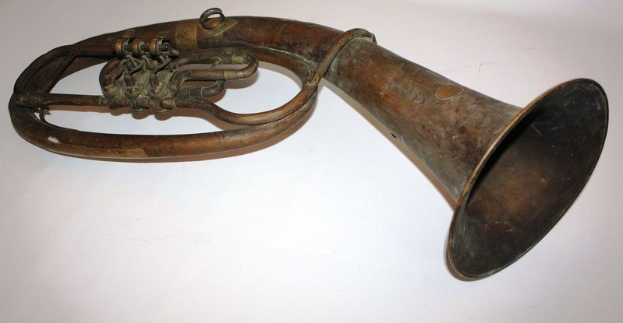 Altes Messinghorn mit glänzendem Finish, gebogenem Hals und aufgeblähtem Schalltrichter, verziert mit kunstvollen Gravuren, auf einem weißen Hintergrund.