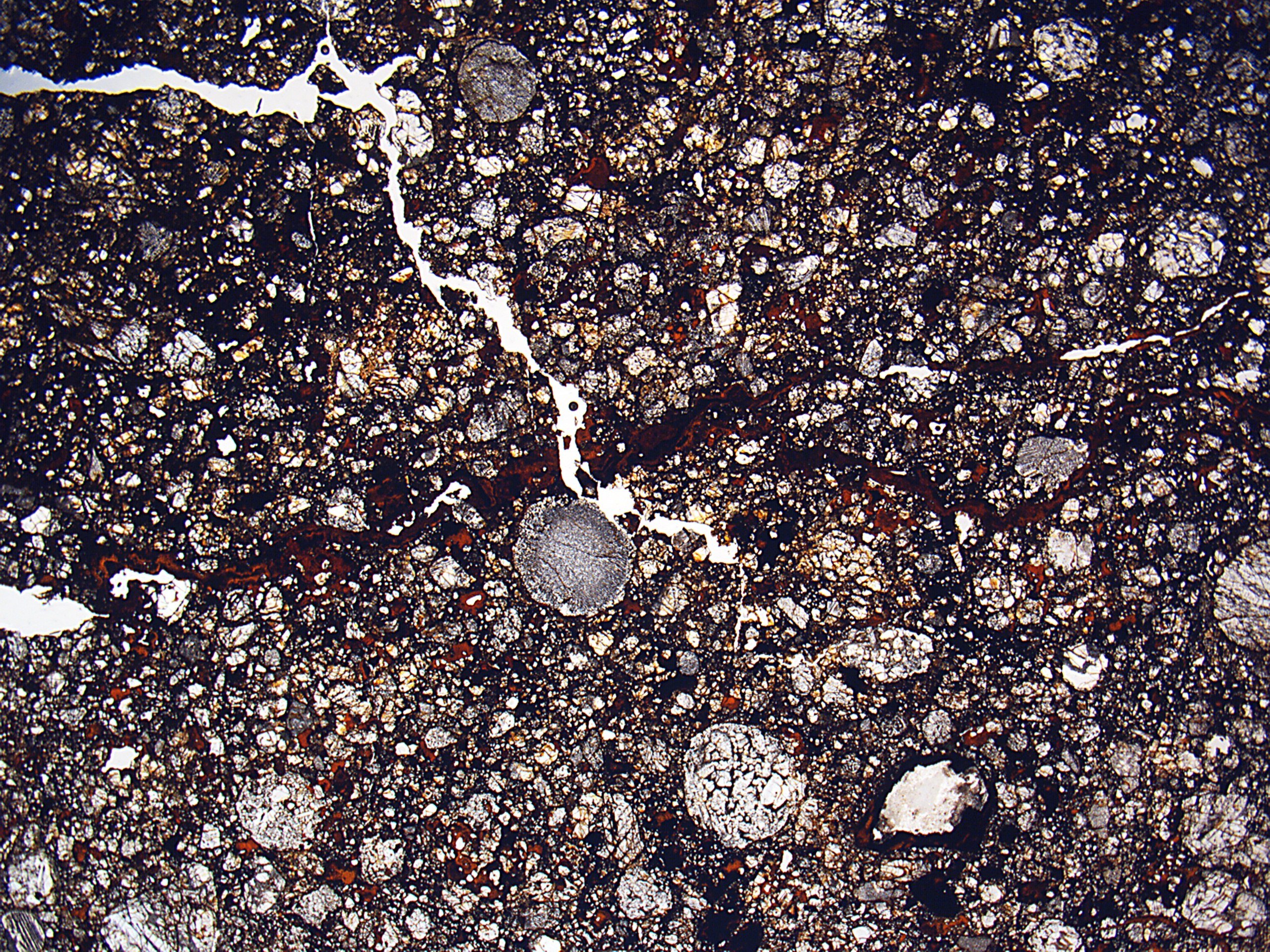 Nahaufnahme einer verschmutzten, rissigen Straße mit rauer, unebener Oberfläche.