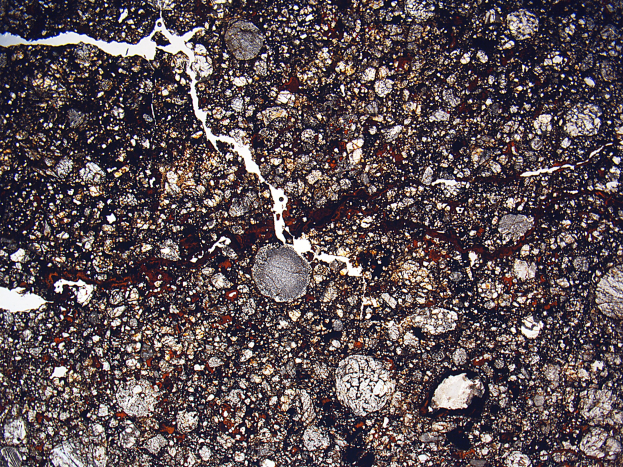 Nahaufnahme einer verschmutzten, rissigen Straße mit rauer, unebener Oberfläche.