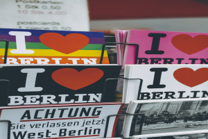 Ein Displayständer mit Büchern und Postern, die den Schriftzug 'Ich liebe Berlin' tragen, vor einem sanft unscharfen Hintergrund.