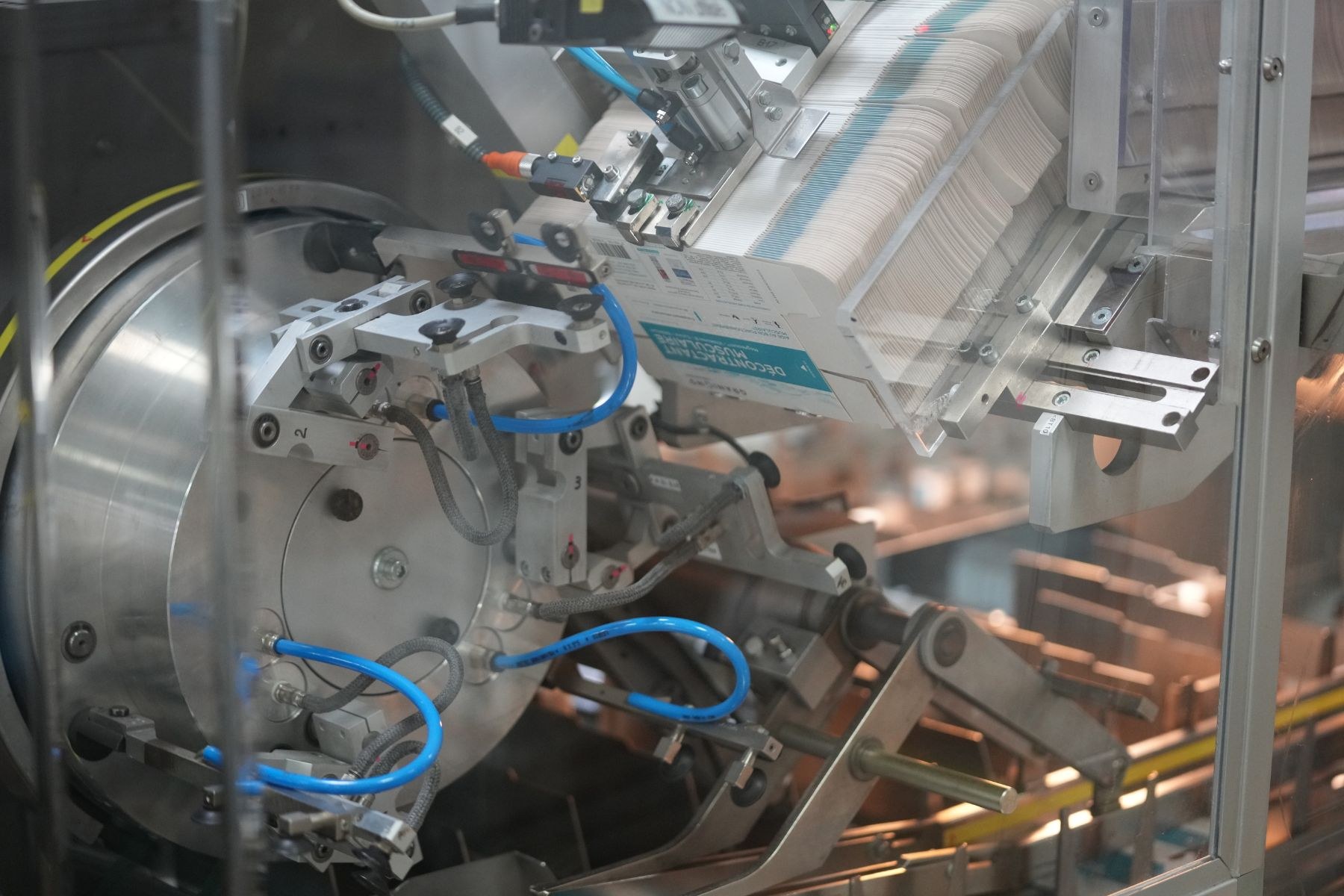 Automatisiertes Verpackungssystem-Maschine auf einem Fabriktisch mit unscharfen Hintergrundobjekten.