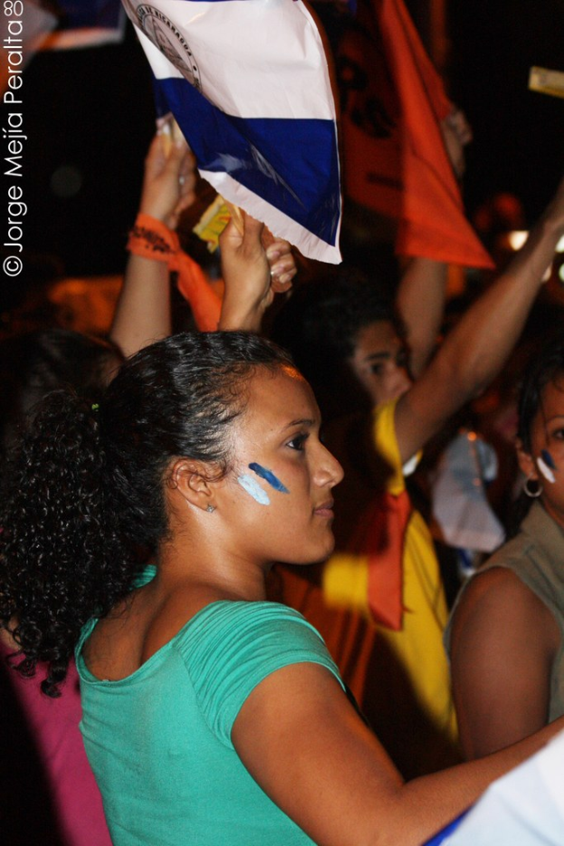 Frauen in grünen T-Shirts bei einer Demonstration mit weißen Tüchern in der Hand, im Hintergrund sind viele weitere Mädchen zu sehen.