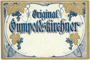 Ein altes deutsches Wein-Etikett mit einer Abbildung von Trauben und Blättern und einem Text, der den Wein-Typ angibt.