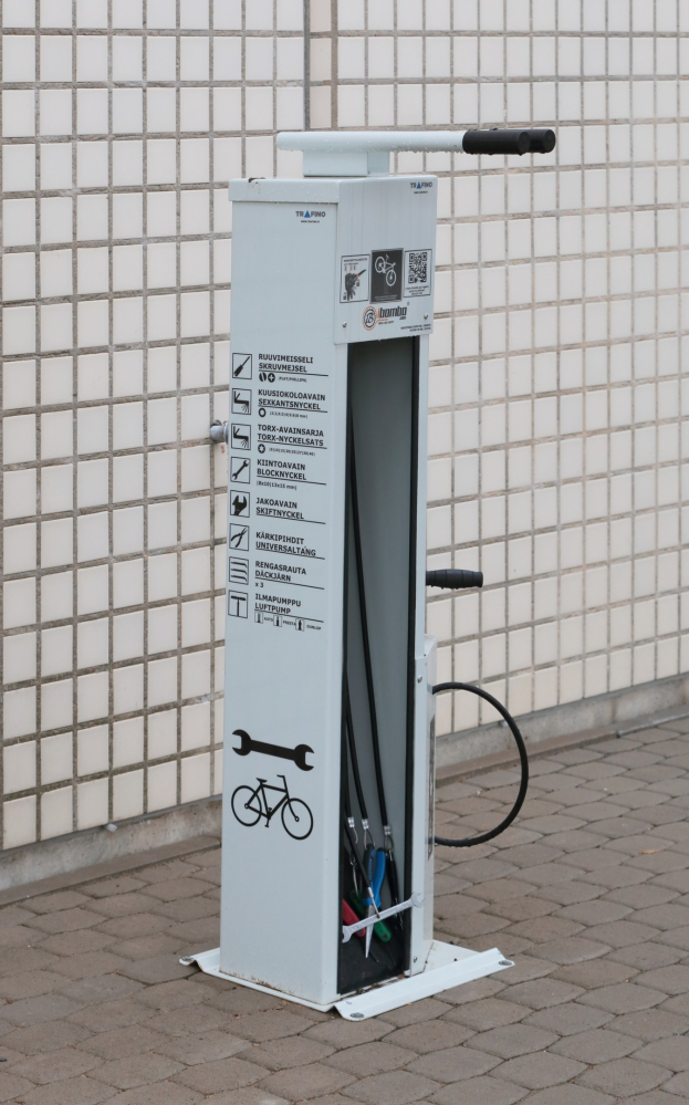 Elektrofahrzeug-Ladestation mit einer bodengestützten Maschine und einer Gebäudewand im Hintergrund.