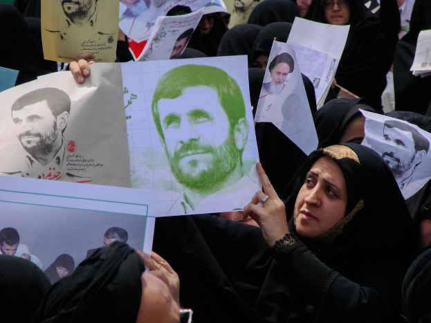 Eine Gruppe iranischer Frauen in schwarzer Kleidung, einige mit Brille, halten Fotos des Präsidenten Mahmoud Ahmadinejad während einer Demonstration in Tehran hoch.