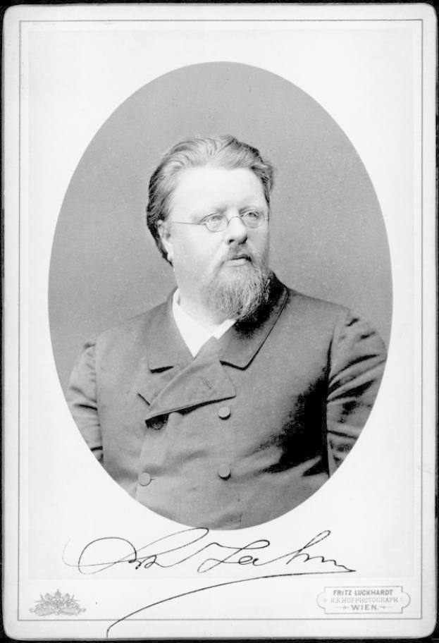 Ein Schwarz-Weiß-Foto eines bärtigen Mannes in einem Mantel und mit Brille, mit dem Text "Fritz Luckhardt, Gründer der deutschen Kommunistischen Partei" unten.