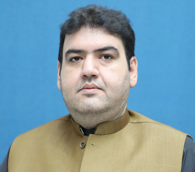 Ein Mann in einer braunen Weste und schwarzem Hemd steht vor einem blauen Hintergrund und sieht verzweifelt und hoffnungslos aus, wahrscheinlich wegen einer lebenslangen Haftstrafe.