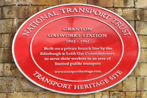 Runder roter Schild an einem Backsteingebäude mit "National Transport Trust"-Text.