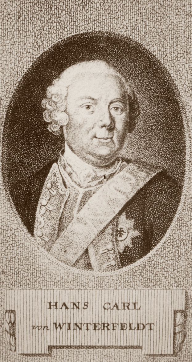 Schwarzes und weißes Foto von Hans Carl von Winterfeldt, ein Mann mit ernstem Gesichtsausdruck, mit Text unten.